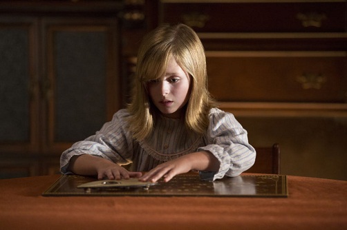 LULU WILSON as Doris in "Ouija: Origin of Evil." Inviting audiences again into the lore of the spirit board, the supernatural thriller tells a terrifying new tale as the follow-up to 2014’s sleeper hit that opened at No. 1. In 1965 Los Angeles, a widowed mother and her two daughters add a new stunt to bolster their séance scam business and unwittingly invite authentic evil into their home. When the youngest daughter is overtaken by the merciless spirit, this small family confronts unthinkable fears to save her and send her possessor back to the other side.